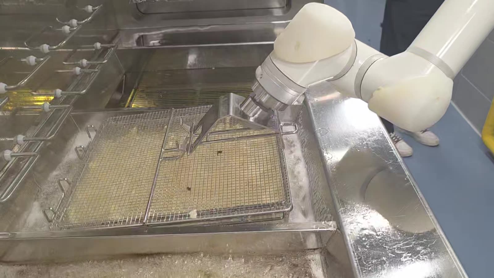 The robot skimming the oil surface with a scraper tool
